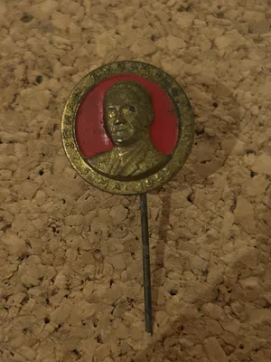Det offisielle 1. mai-merket fra 1953 med et gullfarget relieffportrett av Johan Nygaardsvold.