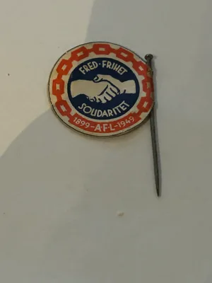 1. mai-merke fra 1949 med håndtrykk-motiv og teksten «1899 – A.F.L. – 1949».